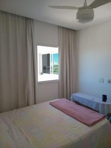 a bedroom with a bed and a window at Quarto próx a Praia do Morro in Guarapari