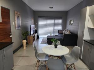 a living room with a table and a couch at Leaf Mbabane CBD Apartment in Mbabane