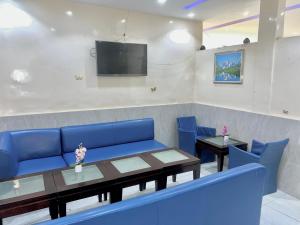 a waiting room with a blue couch and a table at Amsy hotel in Dakar
