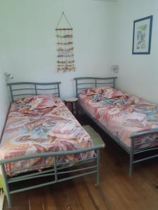 two beds sitting next to each other in a room at Gîte HIBISCUS in Saint-François +9 photos