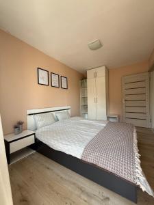 a bedroom with a large bed with a white bedspread at The Walnut Nest in Sapareva Banya