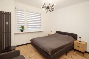 a bedroom with a bed and a window at Kolbi Signature Platinum Residence in Białogard
