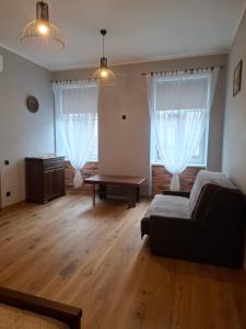 a living room with a couch and two windows at Jūras ielas apartamenti in Limbaži +11 photos