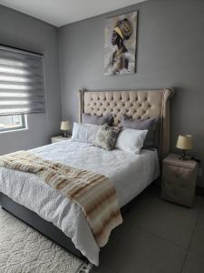 a bedroom with a large bed and two night stands at Leaf Mbabane CBD Apartment in Mbabane +9 photos