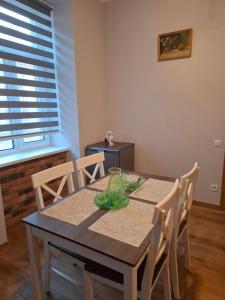 a dining room with a table with chairs and a window at Jūras ielas apartamenti in Limbaži