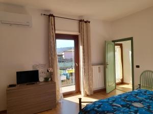 a bedroom with a bed and a tv and a window at alloggio turistico olmata in Montevirginio