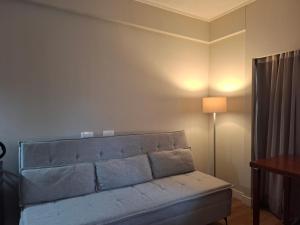 a couch in a living room with a lamp at Flat Borges Lagoa Vl Mariana Ibirapuera com garagem UH1007 in São Paulo +18 photos