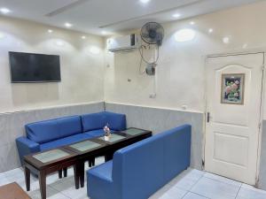 a living room with a blue couch and a table at Amsy hotel in Dakar +15 photos
