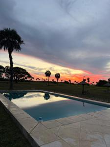 a swimming pool with a sunset in the background at Complejo La Conquista in Goya +11 photos