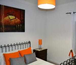ein Schlafzimmer mit einem Bett und einem Gemälde an der Wand in der Unterkunft Casinha das Flores in Reguengos de Monsaraz