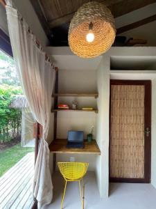 a room with a desk with a laptop and a window at MAHAGUA Casa Holística - Jambreiro, Caraiva, BA in Porto Seguro