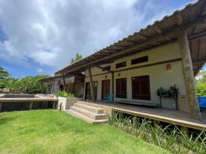 a house with a green lawn in front of it at MAHAGUA Casa Holística - Jambreiro, Caraiva, BA in Porto Seguro