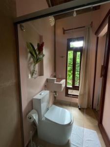 a bathroom with a toilet and a sink and a window at MAHAGUA Casa Holística - Jambreiro, Caraiva, BA in Porto Seguro +3 photos