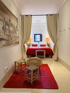 a bedroom with a red bed and a red rug at Riad Dar Balthazar in Marrakesh +64 photos