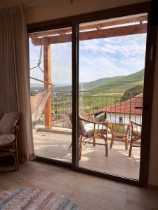 a sliding glass door to a balcony with a view at sunrise valley - זריחת העמק in Yavneʼel