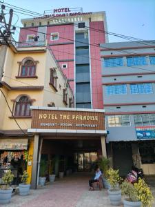 a person sitting in a chair in front of a hotel at Hotel The Paradise in Bihār Sharīf