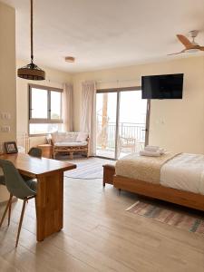 a bedroom with a bed and a table and a couch at sunrise valley - זריחת העמק in Yavneʼel