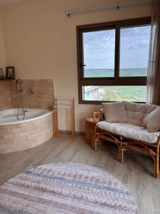 a living room with a couch and a bath tub at sunrise valley - זריחת העמק in Yavneʼel +31 photos