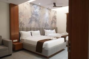 a bedroom with two beds and a painting on the wall at Hotel The Paradise in Bihār Sharīf +103 photos