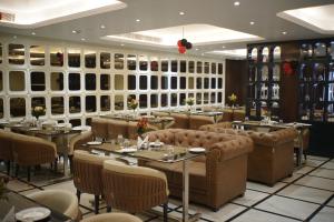 a restaurant with tables and chairs in a room at Hotel The Paradise in Bihār Sharīf