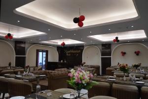 a dining room with tables and chairs and flowers at Hotel The Paradise in Bihār Sharīf