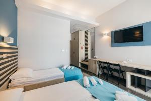 a hotel room with two beds and a desk at Altus Hotel & Spa in Praid