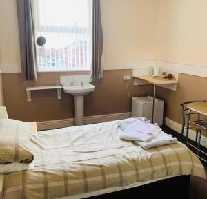 a hospital room with a bed and a sink at Runcorn Jubilee Guest House in Runcorn +1 photo