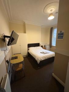 a hotel room with a bed and a television at Runcorn Jubilee Guest House in Runcorn