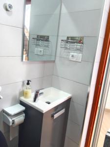 a white bathroom with a sink and a mirror at Casa del Drago in Vega de San Mateo +44 photos