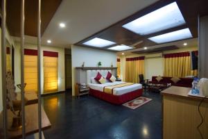 a bedroom with a bed and a living room at Hotel Royal Embassy in Bhilwara