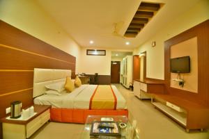 a hotel room with a bed and a television at Hotel Royal Embassy in Bhilwara