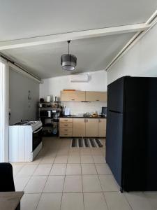a kitchen with a black refrigerator in a room at Elia’s house in Ligia