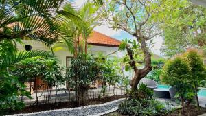 a resort with a pool and trees and a fence at Moonlight Sanur in Sanur