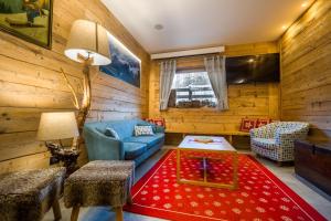 a living room with a blue couch and a red rug at Alpen Chalet - Charme Mountain Hotel - in Schilpario