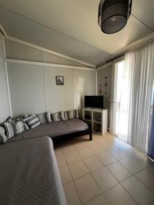a living room with a couch and a television at Elia’s house in Ligia