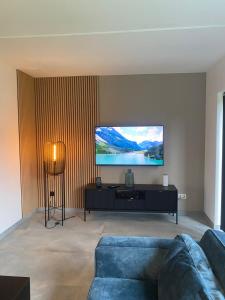 a living room with a couch and a flat screen tv at La villa M in Sart-lez-Spa