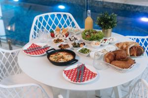 a white table with a lot of food on it at מילה בוטיק - סוויטה מהממת עם 2 חדרי שינה, מתחם מקורה עם בריכה מחוממת, ג'קוזי ספא וסאונה! in ‘Ein Ya‘aqov