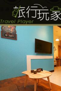 a living room with a tv and a coffee table at Travel Mate B&B in Luodong