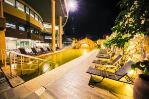uma fila de cadeiras sentadas ao lado de um rio à noite em Doğa Thermal Health & Spa em Pamukkale