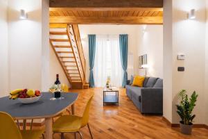 a living room with a table and a couch at Open Sicily Quattro Canti Apartments in Palermo +91 photos