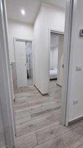 an empty room with a hallway with doors and wooden floors at MAG - Rooms and Apartment in Castelpoto