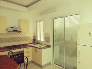 a kitchen with a sink and a refrigerator at Dar-Dhiafa Mayar in Mahdia