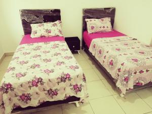 two beds sitting next to each other in a room at Dar-Dhiafa Mayar in Mahdia