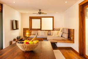 a living room with a couch and a bowl of fruit on a table at Villa Swabrina - Grupo Messina in Jericoacoara