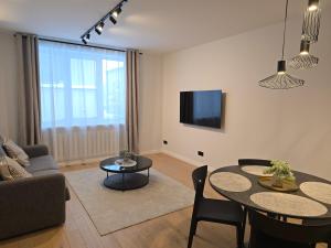 a living room with a couch and a table at Haustory Deluxe Apartment in Klaipėda