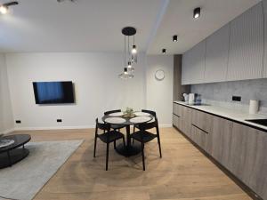 a kitchen and dining room with a table and chairs at Haustory Deluxe Apartment in Klaipėda
