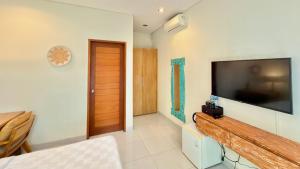 a living room with a large flat screen tv on the wall at Moonlight Sanur in Sanur