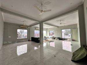 an empty living room with a ceiling fan and a living room at Hotel Tulsi in Haldwāni