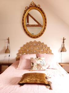 a bedroom with a large mirror above a bed at Le Banellou in Quimper