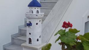 a model of a lighthouse sitting on the stairs at Margarita Studios in Parikia